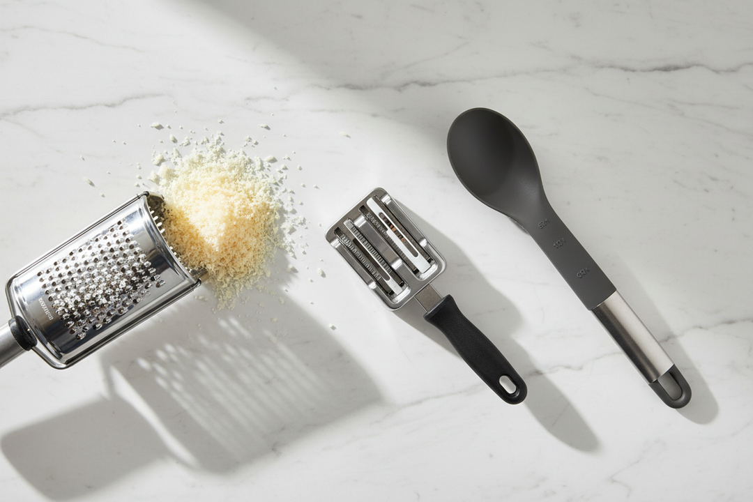 Kitchen efficiency tools - rotary cheese grater, knife sharpener set and 5-in-1 multifunctional spoon on marble