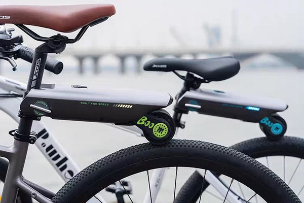Bicycle with a small electric scooter attached to the back, on a blurred background.