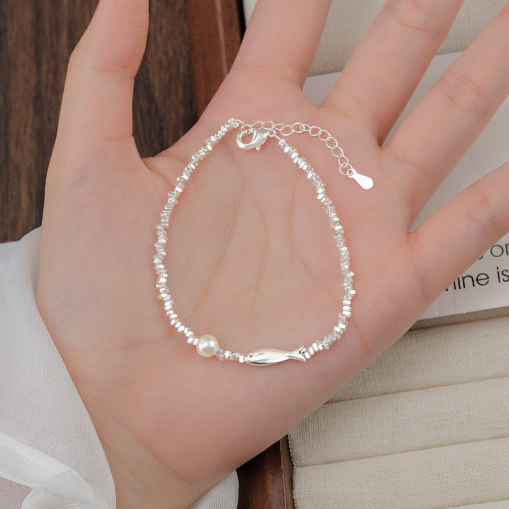 Sterling silver fish pearl bracelet on open palm