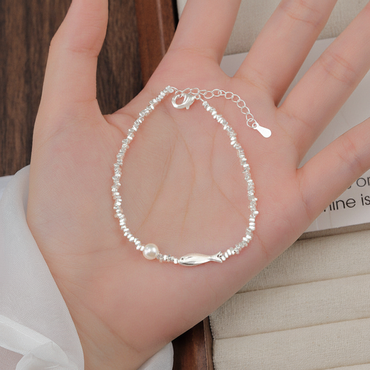 Sterling silver fish pearl bracelet on open palm