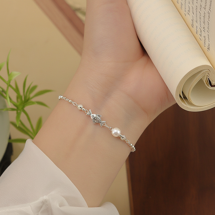 Sterling silver fish pearl bracelet wrist raised with plant